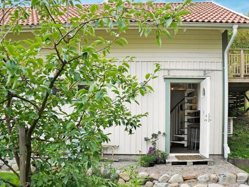 ein kleines weißes Haus mit einer Veranda und einer Tür in der Unterkunft 5 person holiday home in Fj llbacka in Fjällbacka