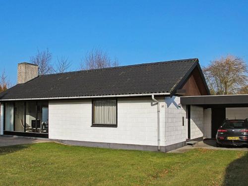 a white house with a black roof at 4 person holiday home in V ggerl se in Bøtø By