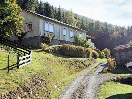 オッタにある6 person holiday home in Ottaの未舗装路横の丘の上の家