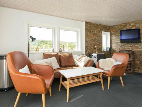 sala de estar con 2 sillas y sofá en 4 person holiday home in Bl vand, en Blåvand