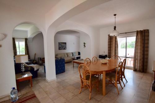 a dining room and living room with a table and chairs at Villa Oleander in Vale do Lobo