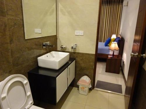 uma casa de banho com um lavatório e um WC em Water Park Residencies em Nugegoda