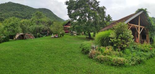 a grassy yard next to a building with a house at Na Okić - a private forest oasis in Sveti Martin pod Okićem