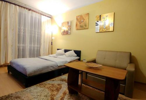 um quarto com uma cama, uma mesa e um sofá em Apartament TwojaNoc em Mielec