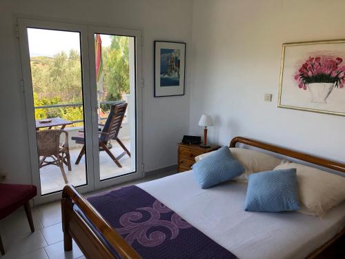 sypialnia z łóżkiem oraz balkon ze stołem w obiekcie Apartment KoKa w mieście Ermioni