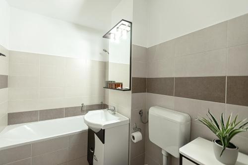 a bathroom with a sink and a toilet and a bath tub at Montana Apartment City Center in Braşov