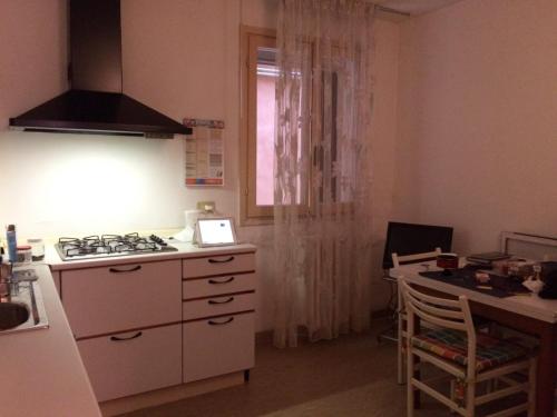 uma cozinha com um fogão, uma mesa e uma janela em Ca’Ghironda em Veneza