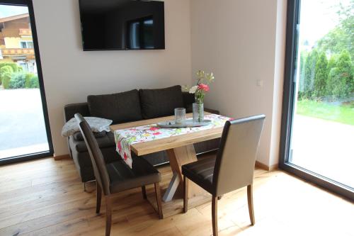 a dining room with a table and a couch at Apartments MountainView in Maishofen