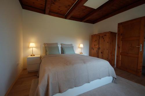 um quarto com uma cama grande e 2 candeeiros em Vacationhome in the vineyards em Viena