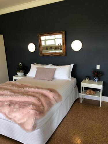 a bedroom with a bed and a mirror on the wall at The Lake House Retreat in Keith
