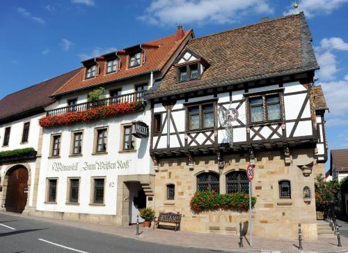 a white building with flowers on the side of it at Weinkastell Zum Weissen Ross in Kallstadt