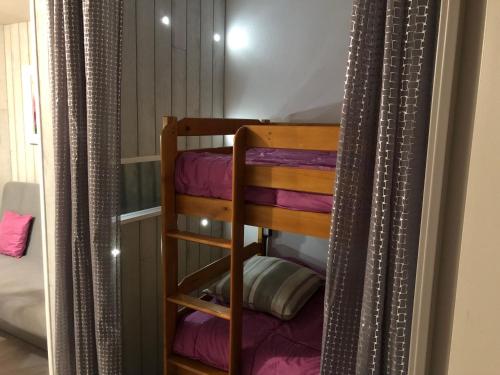 Zimmer mit einem Etagenbett und lila Decken in der Unterkunft Résidence Bellevue in Cauterets