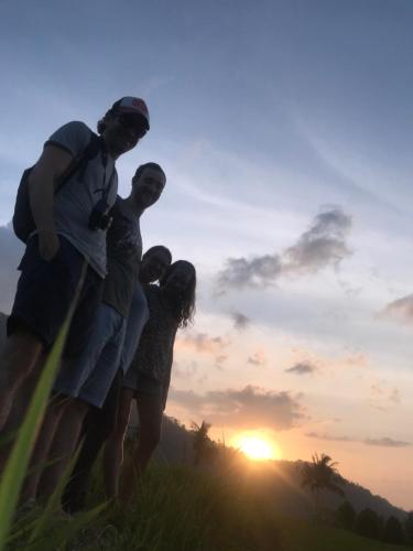 a group of people standing on a hill at sunset at Sugi Gede Homestay in Singaraja