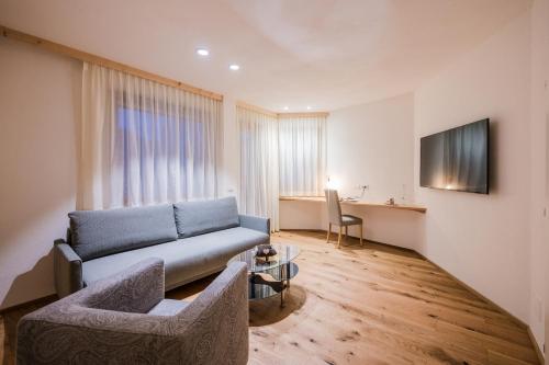 a living room with a couch and a table at Alpenwellnesshotel St. Veit in Sesto