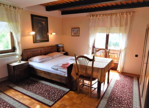 um quarto com uma cama, uma mesa e cadeiras em Apartment Ana em Ljubno