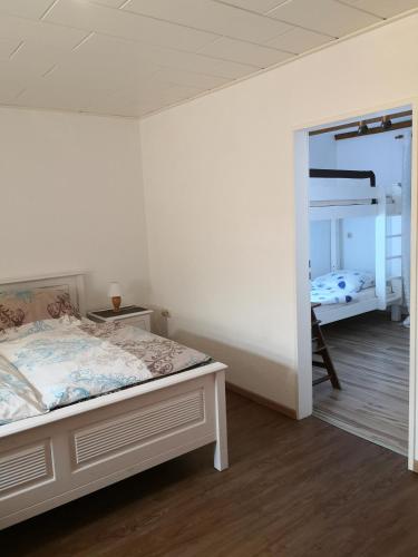 a bedroom with a bed and a bunk bed at Ostfriesisches Landhaus in Wittmund