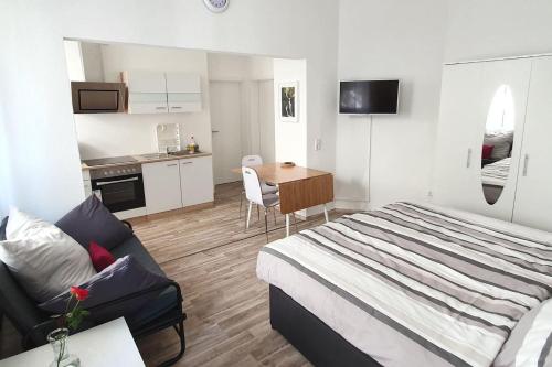 sypialnia z łóżkiem i stołem oraz kuchnia w obiekcie H-Apartment 2 w mieście Triberg