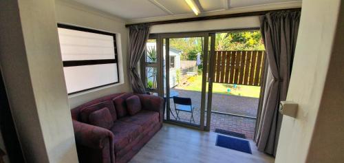 a living room with a couch and a large window at Knys-to-stay in Knysna