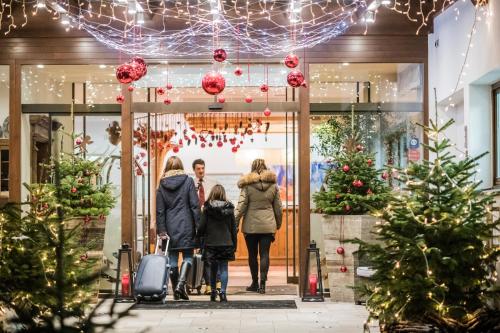 a group of people walking into a store with christmas trees at Alpenwellnesshotel St. Veit in Sesto