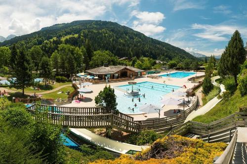 a resort with a swimming pool in the mountains at Bel appartement avec vue exceptionnelle in Le Grand-Bornand