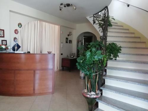 a lobby with stairs and a reception desk with a plant at La Quercia in Cosenza