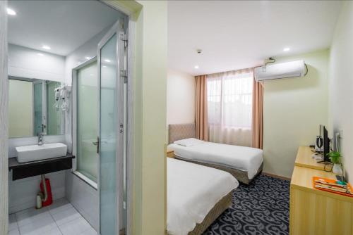 a hotel room with two beds and a sink at Hangzhou Memory Travel International Hotel-Edge Westlake in Hangzhou