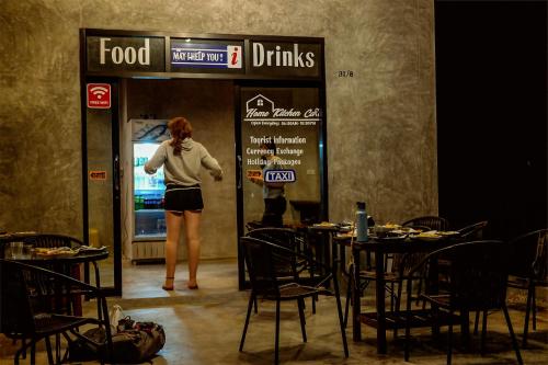a woman standing in front of a food drink machine at Baan i Talay Chumphon บ้านไอทะเลชุมพร in Chumphon