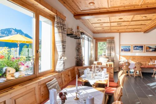 a restaurant with tables and chairs and windows at Hostel by Randolins in St. Moritz