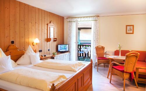 a hotel room with a bed and a table and chairs at Landhaus Cornelia in Bad Birnbach