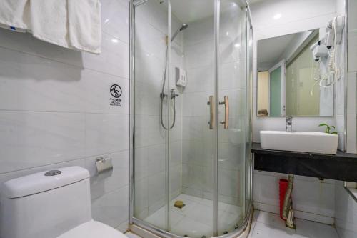 a bathroom with a shower and a toilet and a sink at Hangzhou Memory Travel International Hotel-Edge Westlake in Hangzhou