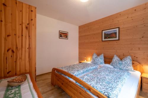 1 dormitorio con 1 cama con pared de madera en Mantingerhof, en Funes