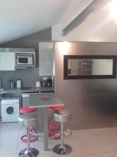 - une cuisine avec un comptoir et des tabourets dans l'établissement Maison proche de Paris 15 minutes, à Deuil-la-Barre