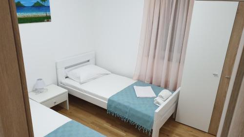 ein kleines Schlafzimmer mit einem Bett und einem Spiegel in der Unterkunft Korina Apartments Mandre in Mandre