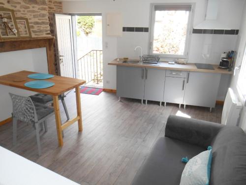 a living room with a table and a kitchen at Chez Papy et Mamie in Aubazines
