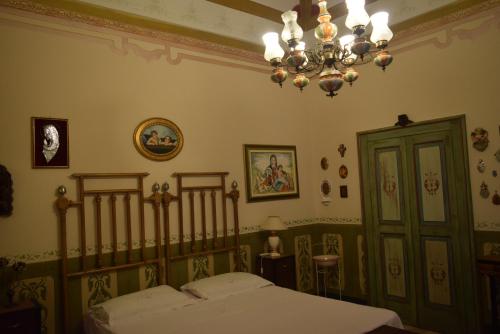 a bedroom with a bed and a chandelier at Appartamento Il Campanile in Muro Leccese