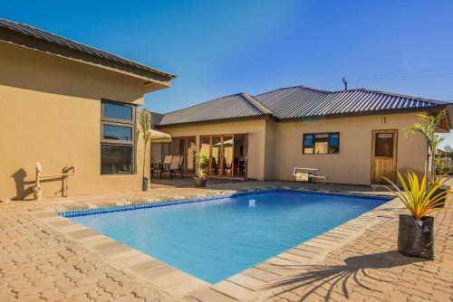 - une piscine en face d'une maison dans l'établissement PeaconWood Boutique Villa, à Palatswe