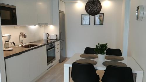 een keuken met een tafel en stoelen in een kamer bij Feels like Home City Holvi in Jyväskylä