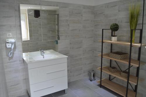 ein Bad mit einem Waschbecken und einem Spiegel in der Unterkunft Gite de la kirneck in Valff