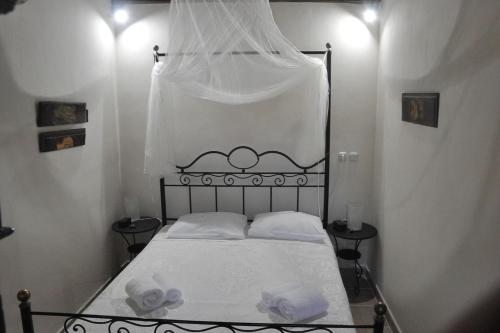 a small bedroom with a bed with white sheets at Anemos - Holiday Beach Houses in Keratokampos