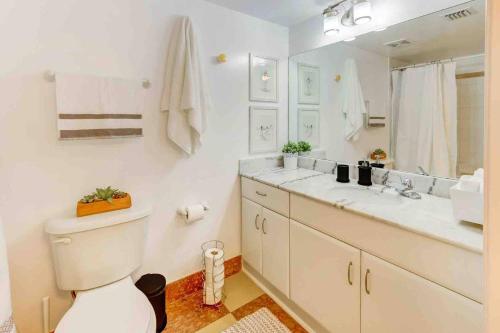 y baño con aseo, lavabo y espejo. en 2 Beautiful Apartments in Miami Brickell, en Miami