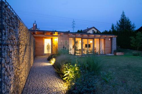a house with a stone wall in front of a yard at Charming house@LK-living in Liberec