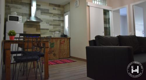 a kitchen and a living room with a table and a couch at L'Hostalet d'Arenys de Mar in Arenys de Mar