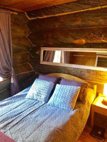 a bedroom with a bed in a log cabin at Villa Karhuntähti in Luosto