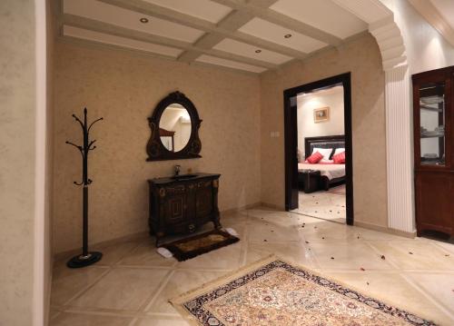 ein Wohnzimmer mit einem Spiegel und ein Zimmer mit einem Bett in der Unterkunft Mandareen Al Sharq Serviced Apartments in Az Zulfi