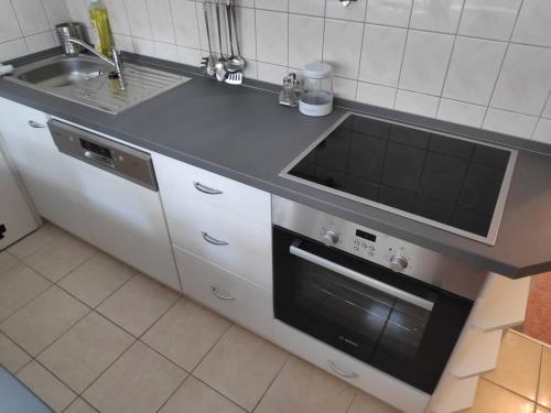 a kitchen with a sink and a stove at Kölcsey Apartman in Szekszárd