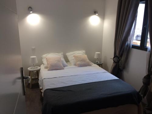 a bedroom with a bed with pillows and a window at Maison bord mer in Labenne
