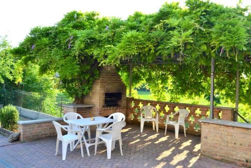 un patio con mesa y sillas bajo un árbol en B&B Reginetta, en Casteggio