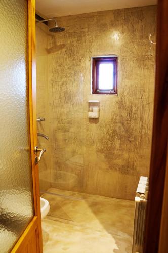 a bathroom with a shower with a glass door at Hostería La Soberana in El Calafate