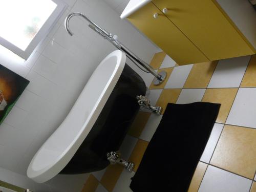 een badkamer met een urinoir en een zwarte handdoek bij Route de Nieul in Le Girouard