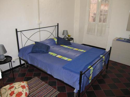een slaapkamer met een bed met blauwe lakens en blauwe kussens bij CASA ROSSA in Borgomaro